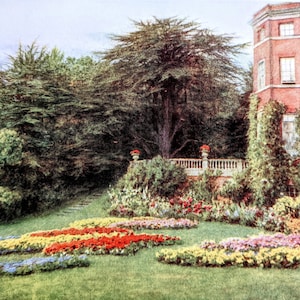 May include: A vibrant garden scene featuring a large tree, colorful flower beds, and a red brick building. The flower beds display rows of yellow, red, and blue flowers. A white balustrade and a stone staircase are also visible.
