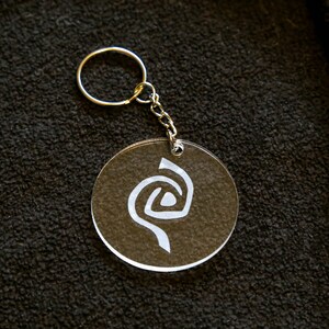 Roswell inspired crystal clear keychain with a frosted Antar symbol on. image 2