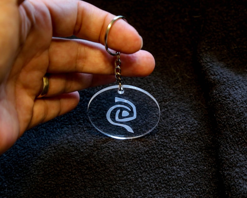 Roswell inspired crystal clear keychain with a frosted Antar symbol on. image 1