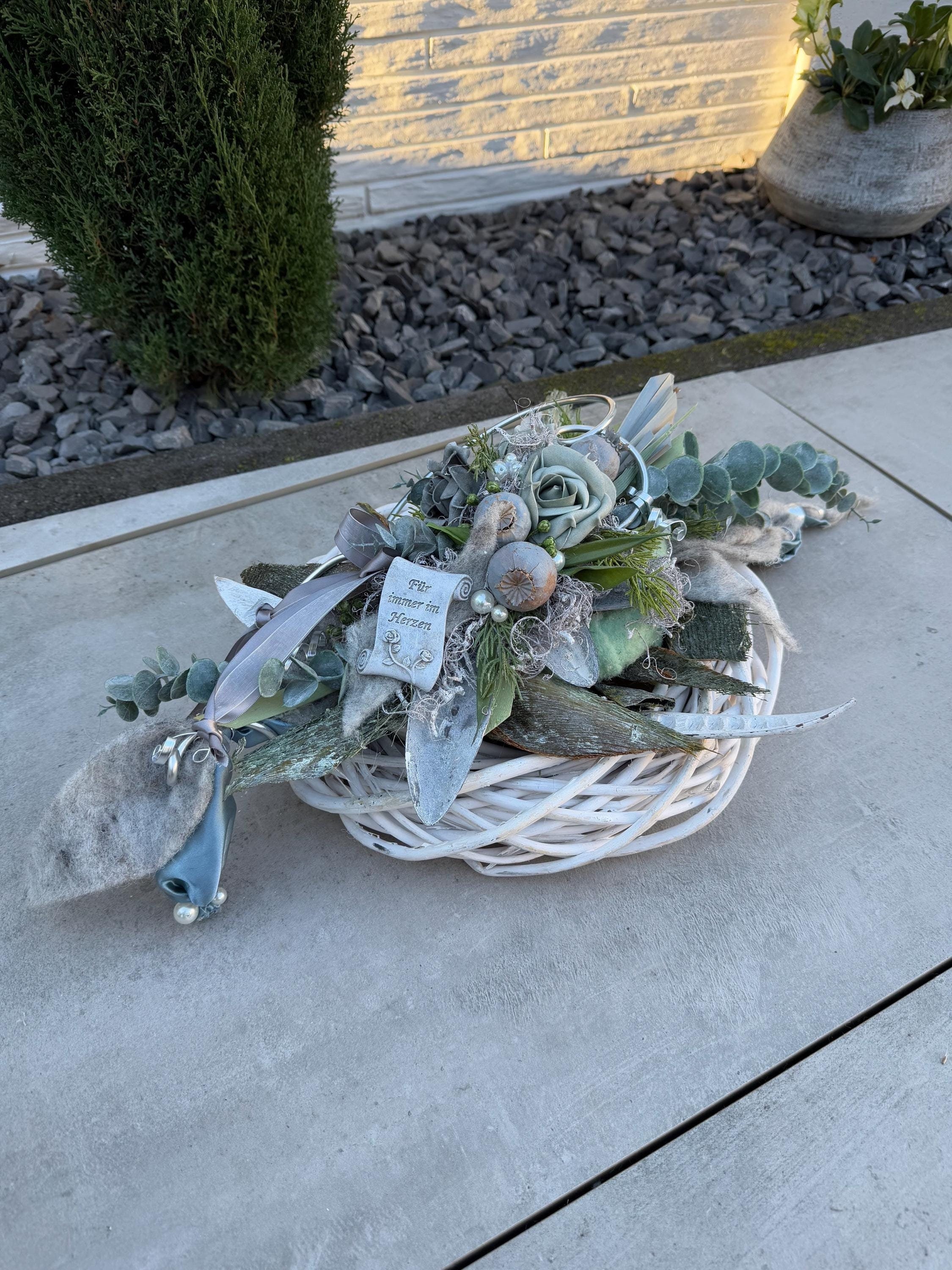 Grabschmuck zu Allerheiligen oder Gedenktag. Grabgesteck auf Rattankranz