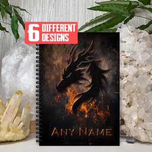 May include: A black and orange spiral notebook with a black dragon design and the text "ANY NAME" on the cover. The notebook has a textured background and a fiery orange design.