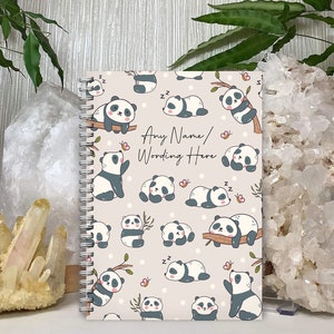May include: A spiral bound notebook with a light gray cover featuring a repeating pattern of black and white panda bears in various poses. The text "Any Name/Wording Here" is printed in black on the cover.