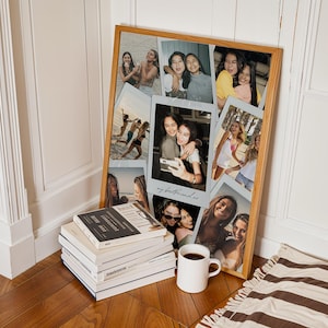 May include: A rectangular wooden frame containing a collage of multiple candid photographs of friends. The central photo features the handwritten text "my bestfriend xo" in cursive script. The frame is positioned next to a stack of books and a white mug.