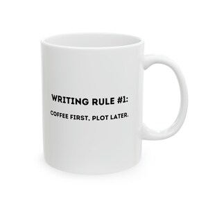 May include: White ceramic coffee mug with black text that reads "Writing Rule #1: Coffee First, Plot Later."