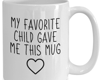May include: White ceramic coffee mug with black text that reads "My favorite child gave me this mug" with a black heart below the text.