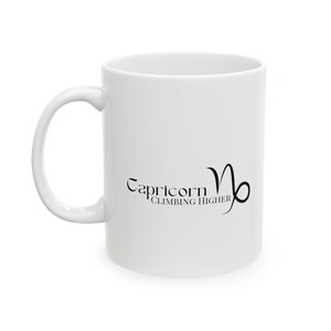 May include: White ceramic mug with a black graphic of the Capricorn zodiac sign and the text "Capricorn Climbing Higher".