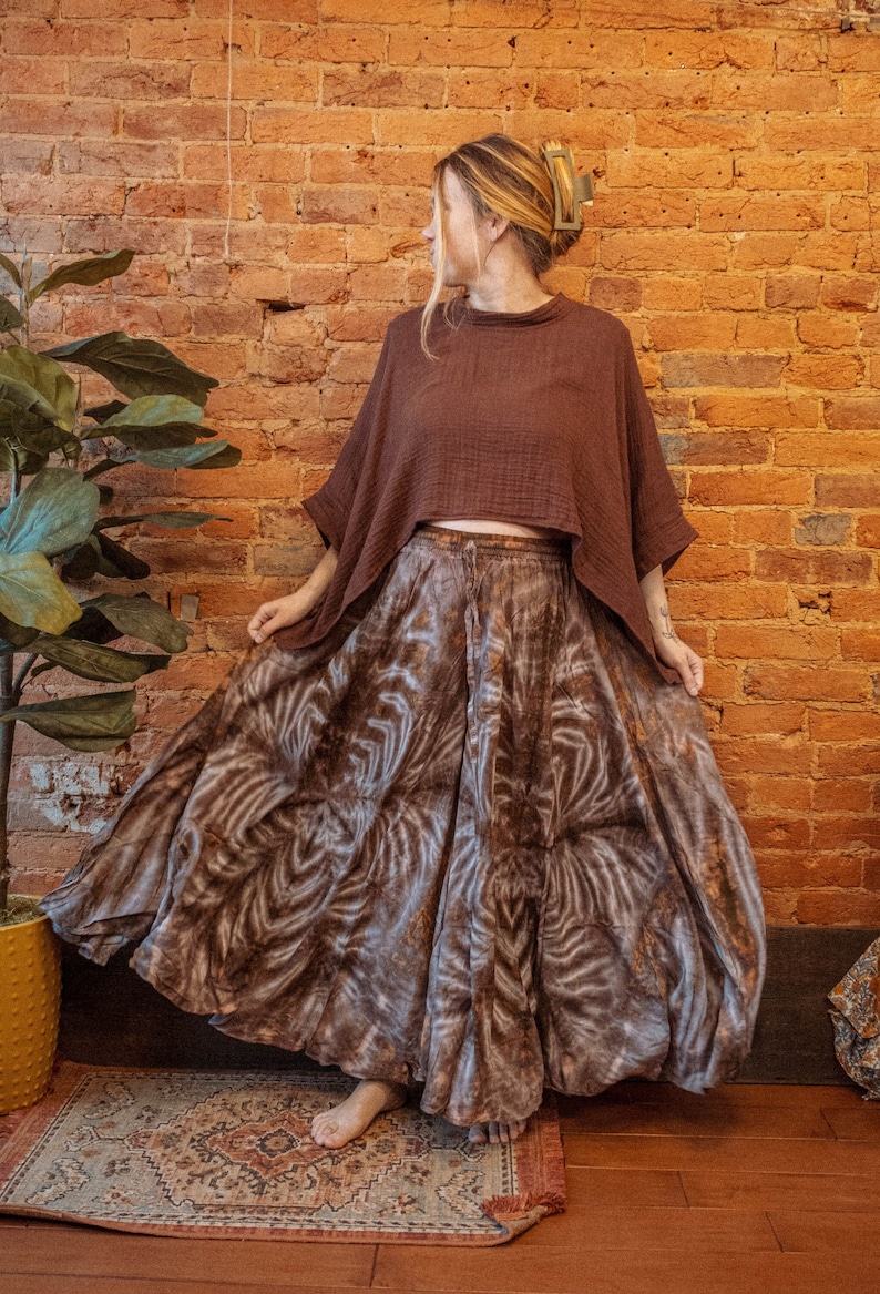 May include: A brown and white patterned maxi skirt with a brown, loose-fitting top. The skirt has a flowing, tiered design and the top has a wide, cropped silhouette.