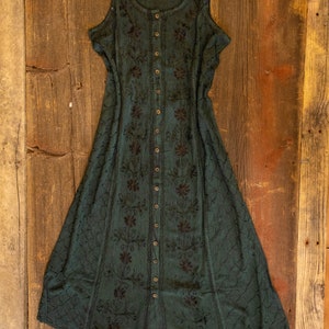 May include: A dark green sleeveless maxi dress with black embroidery and a button-up front.