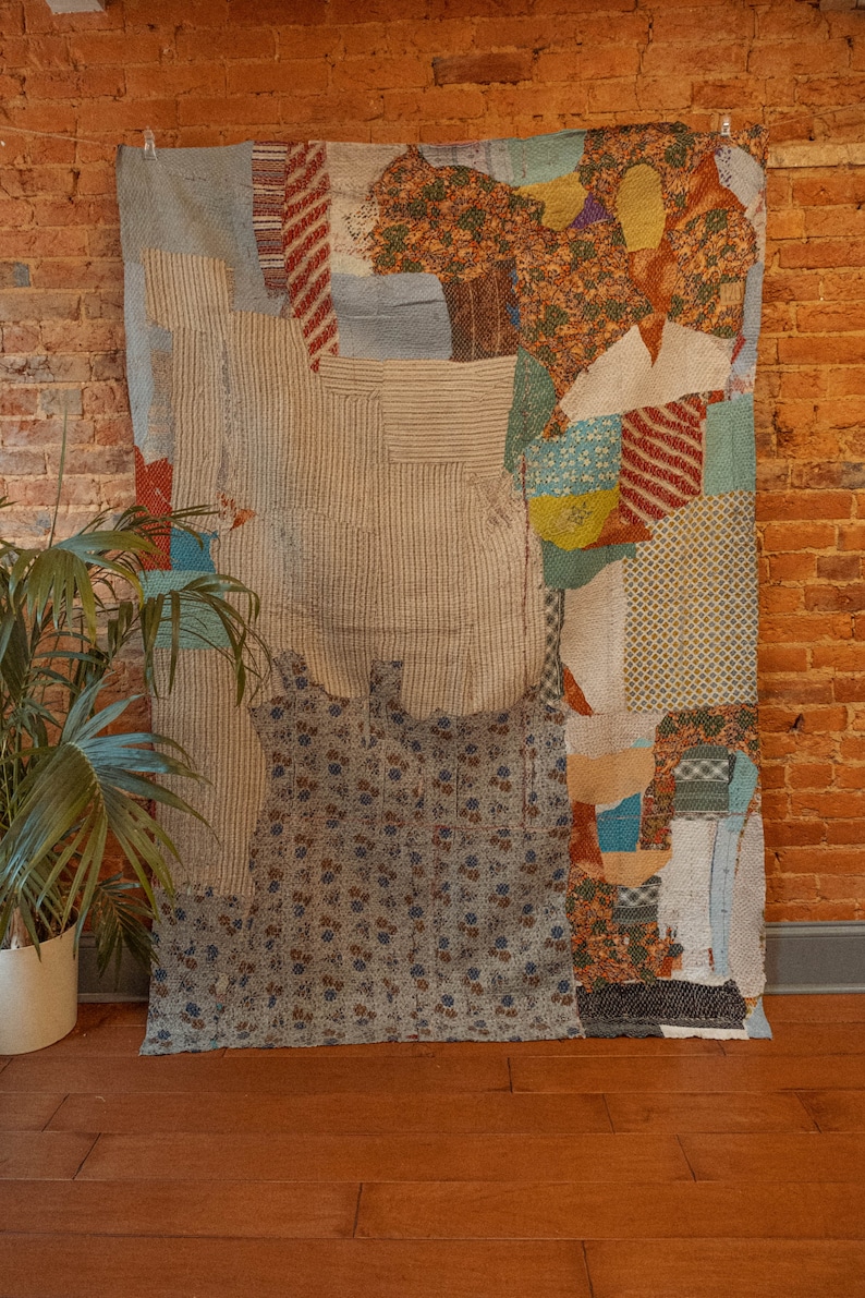 K&ouml;nnte beinhalten: Ein Patchwork-Decken mit einer Vielzahl von Farben und Mustern, darunter Blau, Braun, Rot und Gelb. Die Decke besteht aus verschiedenen Stoffen, die in einem zuf&auml;lligen Muster zusammengen&auml;ht sind.