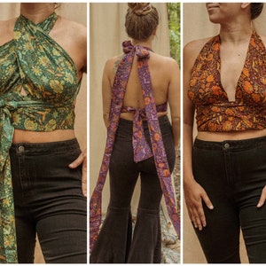 May include: Three different halter tops with a wrap style design. The tops are made of a patterned fabric with a floral design. The tops are shown on three different models.