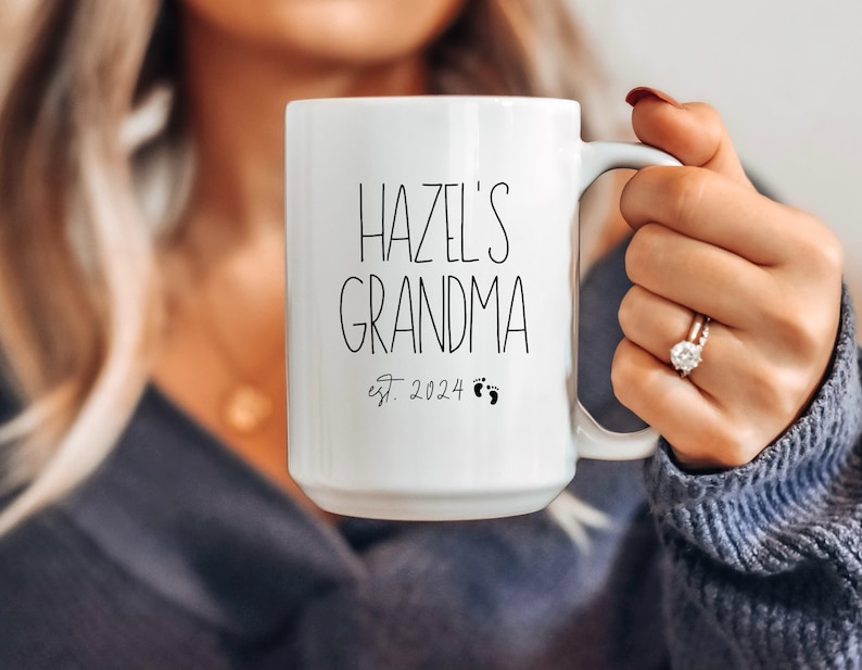 This grandma mug is personalized with the name of the baby and birth year. It reads from top to bottom, name of baby, grandma, established year with tiny baby feet. A bestseller, made in the USA using a high quality white lead free ceramic.