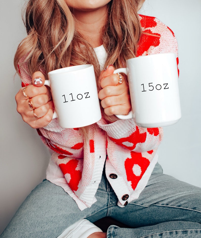 May include: Two white ceramic mugs with black text. The mug on the left says "11oz" and the mug on the right says "15oz".