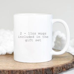 May include: White ceramic mug with black text that reads "2 - 11oz mugs included in the gift set"