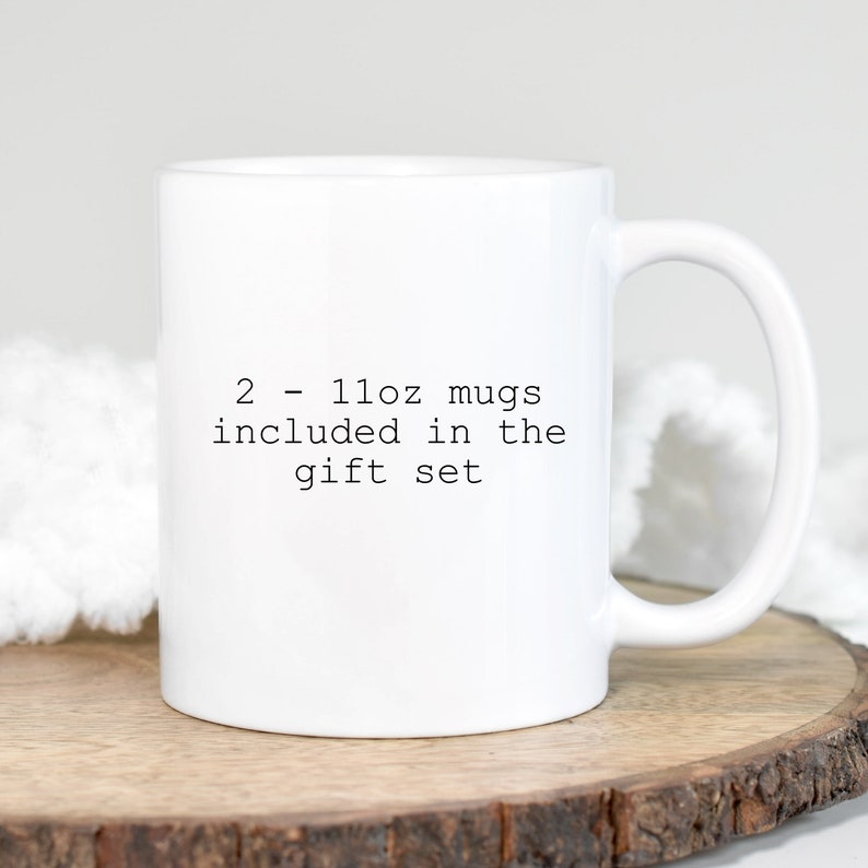 May include: White ceramic mug with black text that reads "2 - 11oz mugs included in the gift set"