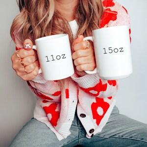 May include: Two white ceramic mugs with black text. The mug on the left says "11oz" and the mug on the right says "15oz".