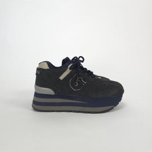 May include: Dark navy blue platform sneaker with a suede upper. Features a navy blue sole with gray stripes and a white accent. The sneaker has a white "G" logo on the side and the letter "N" on the heel.