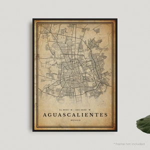 May include: A vintage-style map of Aguascalientes, Mexico, with a beige background and black lines. The map shows the city's streets and landmarks. The coordinates 21.8823° N / 102.2826° W are printed below the map, along with the city's name and "Mexico".