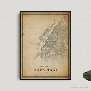 May include: A vintage-style map of Benghazi, Libya, with a beige background and black lines showing the city streets. The coordinates 32.1149° N / 20.0686° E are printed below the map, along with the city name "Benghazi" and "Libya".