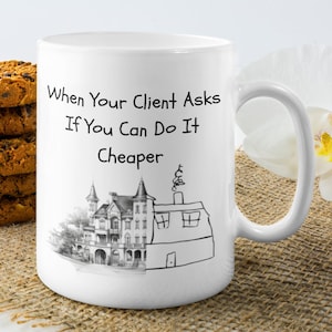 May include: White ceramic mug with a black handwritten message that reads "When Your Client Asks If You Can Do It Cheaper". A black and white illustration of a house is below the text. The house is drawn in a realistic style on the left side of the illustration and in a child-like style on the right side.