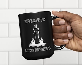 May include: Black coffee mug with a white graphic of a chess king standing in a puddle of tears with the text "Tears of my chess opponents".