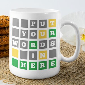 May include: White ceramic mug with a green, yellow, and gray grid pattern. The text "PUT YOUR WORDS IN HERE" is printed on the mug.