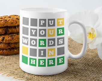 May include: White ceramic mug with a green, yellow, and gray grid pattern. The text "PUT YOUR WORDS IN HERE" is printed on the mug.