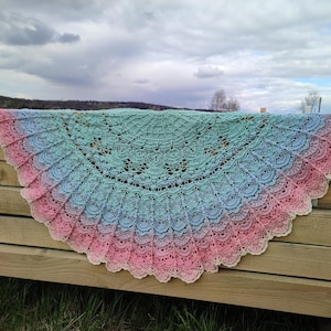 Peut inclure: Un châle crocheté fait à la main, en forme de demi-cercle. Il présente un dégradé de couleurs, allant du rose au bleu puis au vert. Le motif de dentelle complexe ajoute une touche délicate à cet accessoire.