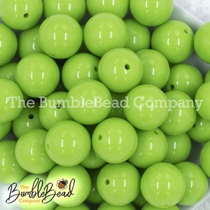 May include: A close-up image of a large quantity of lime green round beads. The beads are smooth and glossy.
