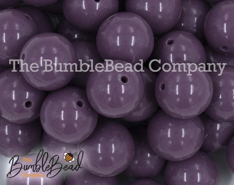 May include: A close-up of a pile of 20mm purple silicone beads. The beads are smooth and shiny, and they have a small hole in the center. The beads are perfect for making jewelry, crafts, and other projects.
