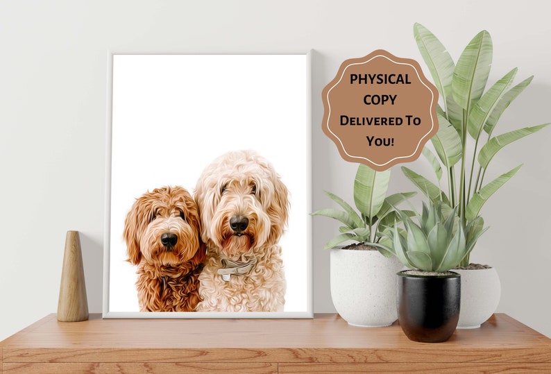 Op de afbeelding: Een ingelijste print met twee gekrulde honden, &eacute;&eacute;n roodbruin en de andere cr&egrave;mekleurig. De honden staan dicht bij elkaar en kijken de kijker aan. De print staat op een houten oppervlak, met planten op de achtergrond. De tekst op de afbeelding luidt "PHYSICAL COPY DELIVERED TO YOU!"