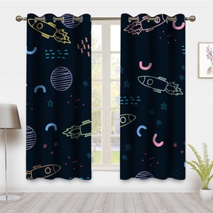 May include: A pair of dark blue curtains with a colorful rocket ship, star, and planet pattern. The curtains have grommets at the top for hanging.