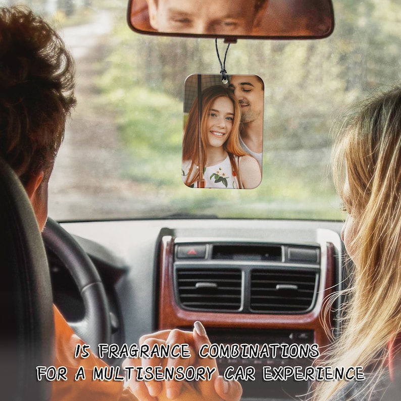 Puede incluir: Un ambientador de coche con una foto de una pareja. La foto est&aacute; en un marco rectangular y est&aacute; colgada del espejo retrovisor. La pareja sonr&iacute;e y mira a la c&aacute;mara.