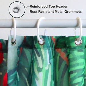 May include: Close-up of a shower curtain with a tropical leaf pattern in shades of green and red. The curtain has a reinforced top header and rust resistant metal grommets.