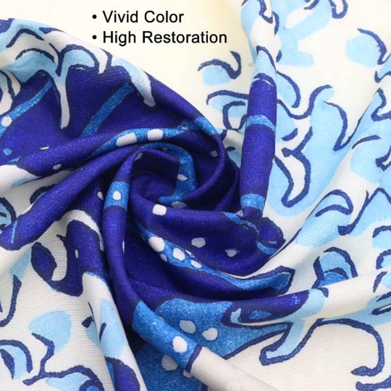 May include: Close-up of a fabric with a vibrant blue and white floral pattern. The fabric is folded, showcasing the intricate design and color variations. The text "Vivid Color" and "High Restoration" is visible.