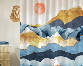 May include: Abstract shower curtain featuring a watercolour-style mountain landscape with gold, blue, and white hues. A large orange sun is in the top left corner.
