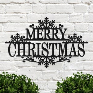 以下が含まれることがあります： 雪の結晶と「メリークリスマス」の文字が書かれた黒い金属製のクリスマスの看板です。