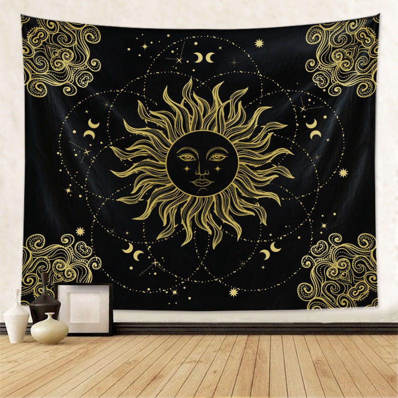 May include: A black tapestry with a gold sun and moon design. The sun has a face and is surrounded by stars and crescent moons.