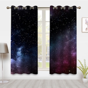 Puede incluir: Un par de cortinas opacas negras con estampado de galaxia que presenta una nebulosa azul oscuro y púrpura con estrellas blancas.