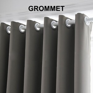 May include: Gray blackout curtains with grommet top hanging on a white curtain rod. The word "GROMMET" is printed in black above the curtains.
