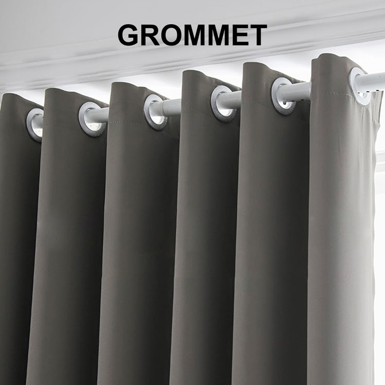 May include: Gray blackout curtains with grommet top hanging on a white curtain rod. The word "GROMMET" is printed in black above the curtains.