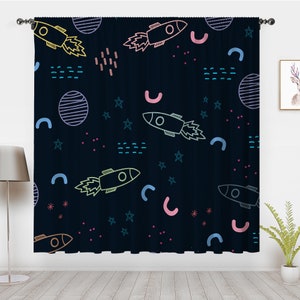 May include: A dark blue curtain with a repeating pattern of rockets, stars, and planets. The rockets are outlined in various colors, including pink, yellow, and blue. The stars are outlined in blue and the planets are outlined in white.