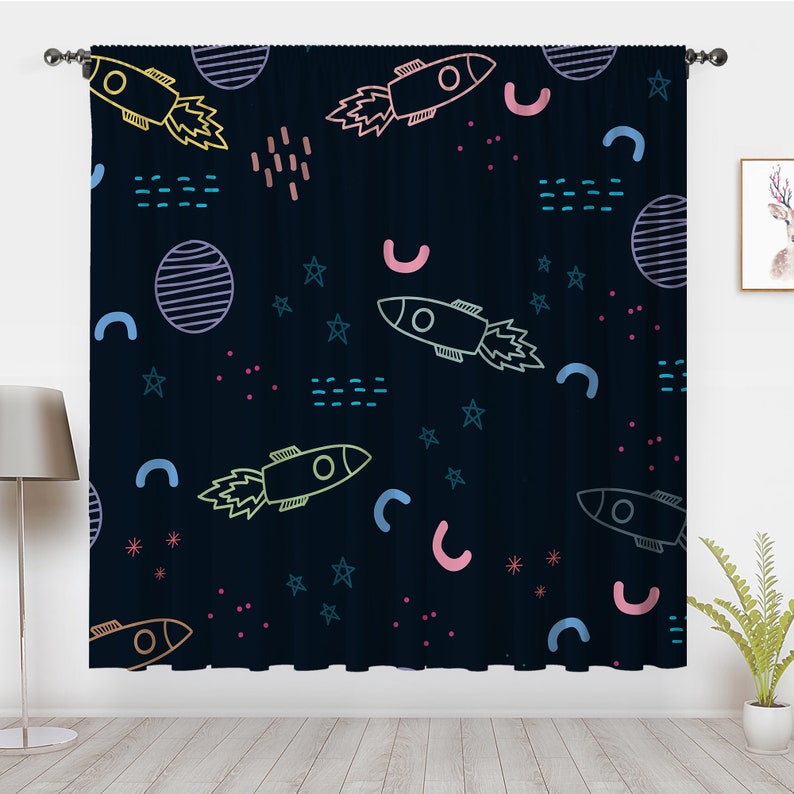 May include: A dark blue curtain with a repeating pattern of rockets, stars, and planets. The rockets are outlined in various colors, including pink, yellow, and blue. The stars are outlined in blue and the planets are outlined in white.