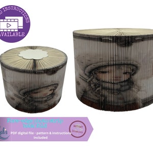 May include: Two cylindrical book folds, one large and one small, with fore-edge photo strip designs. The larger book fold features a girl's face. The image text says "Video Instructions Available" and "Fore-edge photo strip book fold".