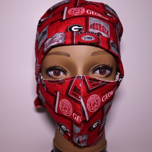 May include: Red and gray fabric face mask with a University of Georgia logo and the words "Bulldogs" and "1785".