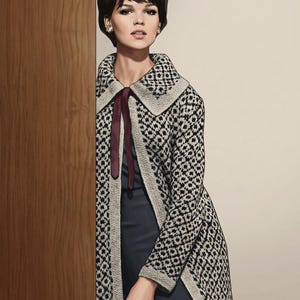 May include: A woman wearing a black and white patterned coat with a wide collar and a burgundy ribbon tie. The coat has a geometric design and is paired with a dark dress. The woman has short dark hair and is wearing earrings.