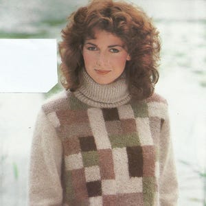 Puede incluir: Un jersey de cuello alto beige con un estampado geométrico en tonos marrones, verdes y blancos. El jersey tiene cuello, puños y dobladillo de canalé. La modelo lleva pantalones verdes. El jersey está hecho de un material de punto suave.