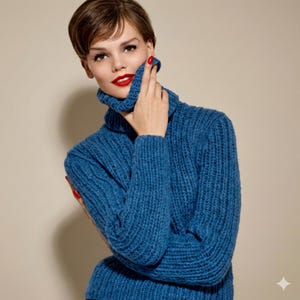 May include: A blue turtleneck jumper with a ribbed knit texture. The jumper has long sleeves and a high collar. The model is wearing the jumper and has red lipstick and nail polish.