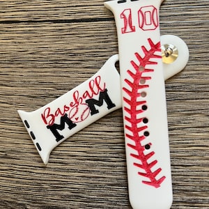Puede incluir: Banda de reloj Apple de silicona blanca con un diseño de puntadas de béisbol rojas y el número "10" con un gráfico de béisbol. La otra banda tiene el texto "Baseball Mom" con un gráfico de béisbol.