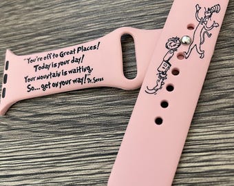Puede incluir: Banda de reloj Apple de silicona rosa con un estampado negro de un gato y el texto "On the Places You'll Go" y "Dr. Seuss". El otro lado de la banda tiene un estampado negro del texto "You're off to Great Places! Today is your day! Your mountain is waiting, So... get on your way! Dr. Seuss"