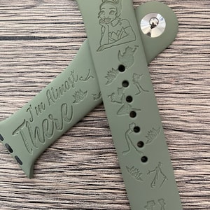 May include: Green silicone watch band with a princess Tiana design and the text "I'm Almost There".